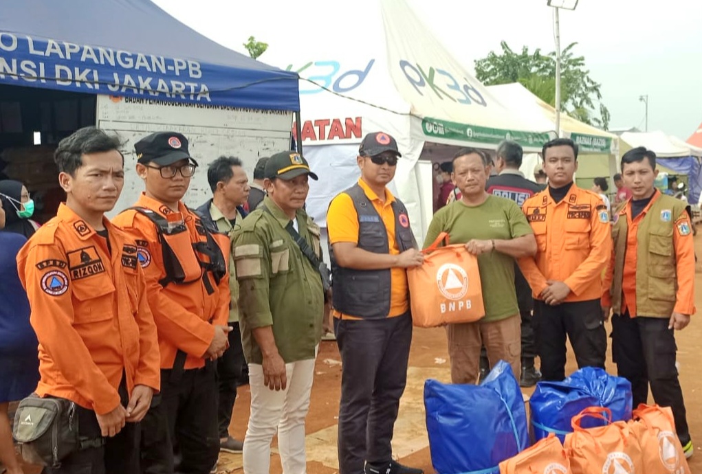 Direktur Dukungan Sumber Daya Darurat BNPB, Agus Riyanto menyerahkan bantuan logistik kepada pos lapangan pengungsian warga terdampak kebakaran pemukiman Kapuk Muara, Jakarta Utara pada Senin (9/6/2025)/ BNPB. 