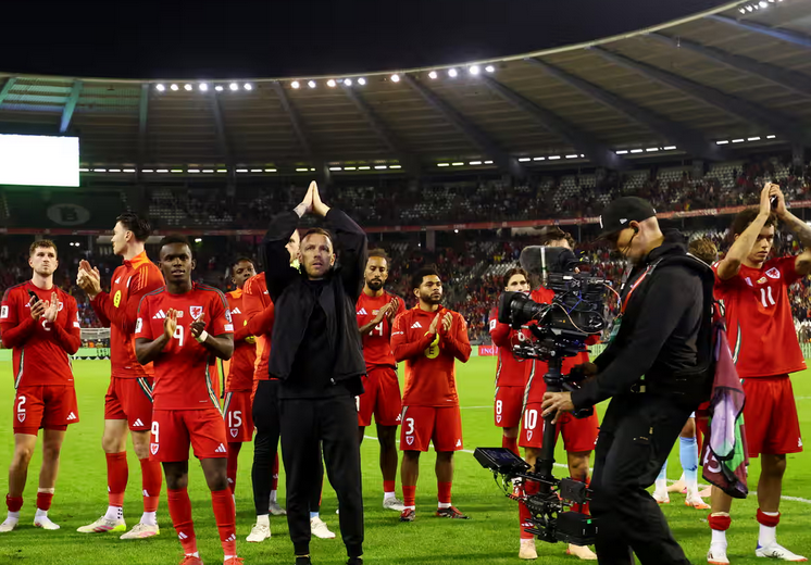 Craig Bellamy and his players applaud the Wales fans after the seven-goal thriller in Brussels. Photograph: Yves Herman/Reuters
